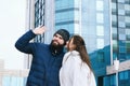 Love story of couple walking in city. Young business man in a blue jacket with a beard. And a cute woman in long coat Royalty Free Stock Photo