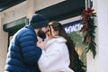 Love story of couple walking in city. Young business man in a blue jacket with a beard. And a cute woman in long coat Royalty Free Stock Photo