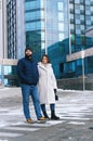 Love story of couple walking in city. Young business man in a blue jacket with a beard. And a cute woman in long coat Royalty Free Stock Photo