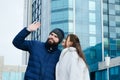 Love story of couple walking in city. Young business man in a blue jacket with a beard. And a cute woman in long coat Royalty Free Stock Photo