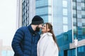 Love story of couple walking in city. Young business man in a blue jacket with a beard. And a cute woman in long coat Royalty Free Stock Photo