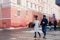 Love story of couple walking in city. Young business man in a blue jacket with a beard. And a cute woman in long coat Royalty Free Stock Photo