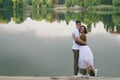 Love story of funny couple walking near river in hard rainfall with umbrella. cute man and woman in white skirt, yellow sweater Royalty Free Stock Photo