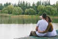 Love story of funny couple walking near river in hard rainfall with umbrella. cute man and woman in white skirt, yellow sweater Royalty Free Stock Photo