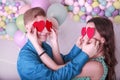 Love story. Happy couple in love holding two paper hearts, apply paper hearts to each other`s eyes