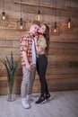 Love story. Happy young couple, hugging each other, girl with a symbol of love, candy in the form of a heart. In plaid shirts