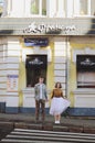 Love story of stylish funny couple: young man in a t-shirt. And a cute young woman in white skirt