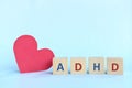 Love and support kids with ADHD or attention deficit hyperactivity disorder concept. ADHD letters on wooden blocks.