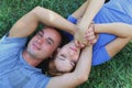 Love and tenderness. young couple holding hands lying on the lawn