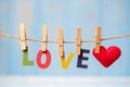 LOVE text and Red heart shape decoration hanging on line with copy space for text on blue wooden background. Love, Wedding, Royalty Free Stock Photo