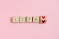 Love text with red heart on Wooden cubes on blue background