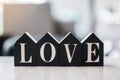 Love text with wooden Home model  on table office. New House, Financial, Property, Happy Valentines day and real estate concepts Royalty Free Stock Photo
