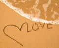 Love - text written by hand in sand on a beach Royalty Free Stock Photo