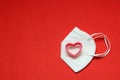 Love in times of pandemic and covid, kn95 protection mask with hearts on red background, Valentine`s day