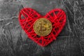 Love to bitcoins. Coin Bitcoin lies on a red heart in a flame of fire