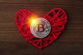 Love to bitcoins. Coin Bitcoin lies on a red heart in a flame of fire