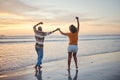 Love, travel and happy couple at beach enjoying summer vacation or fun honeymoon at sunset while holding hands and being Royalty Free Stock Photo