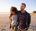 Love, travel and happy couple at beach with hug, support or bonding on sunset walk in nature. Happy, care and people Royalty Free Stock Photo