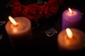 Love triangle and broken relationship concept. Broken glass splinters and three burning candles on black background Royalty Free Stock Photo