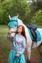 Redhead girl and white horse in the forest