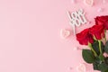 Top view photo of red roses, heart shaped candles, inscription love you on pastel pink background Royalty Free Stock Photo