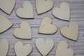 Love Valentines day background, group of light wooden hearts spread on gray striped table, flat lay