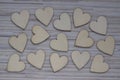 Love Valentines day background, group of light wooden hearts spread on gray striped table, flat lay