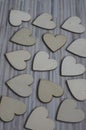 Love Valentines day background, group of light wooden hearts spread on gray striped table, flat lay