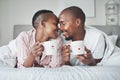 Love, valentines day and black couple gift cups lying in bed in the morning drinking coffee in the bedroom together Royalty Free Stock Photo