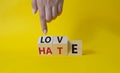 Love vs Hate symbol. Businessman Hand points at wooden cubes with words Hate and Love. Beautiful yellow background. Valentines day Royalty Free Stock Photo