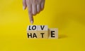 Love vs Hate symbol. Businessman Hand points at wooden cubes with words Hate and Love. Beautiful yellow background. Valentines day Royalty Free Stock Photo