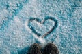 Love winter concept- feet in snow boots and heart in nature Royalty Free Stock Photo
