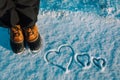 Love winter concept- feet in snow boots and heart in nature Royalty Free Stock Photo