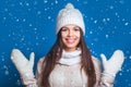 Love winter. Pretty young happy woman in winter clothes Woman surprise showing product .Beautiful girl with curly hair pointing t Royalty Free Stock Photo