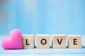 LOVE wooden cubes with pink heart shape decoration on blue table background and copy space for text. Love, Romantic and Happy Royalty Free Stock Photo