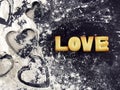 love word, biscuit cookies lettering with heart shaped pastry cutter and wheat flour on kitchen blackboard table floor Royalty Free Stock Photo