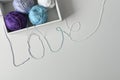 Love word from colorful cotton threads from knitting yarns in white box with copy space under it on white background. Royalty Free Stock Photo