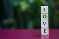 LOVE, word formed by letter pieces on table over blur bokeh background with copy space for text