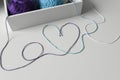 Love word and heart designed from colorful wool threads on white table from knitting yarn in a wood box. Royalty Free Stock Photo