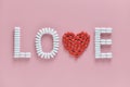 LOVE word made from medicine pills, red heart shape on pink background. Copy space, Concept of Valentine`s Day Royalty Free Stock Photo