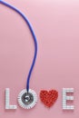 LOVE word made from medicine pills, red heart shape and stethoscope, on pink background. Royalty Free Stock Photo