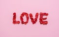 Love word from rose petals on pink background. Valentine day concept Royalty Free Stock Photo