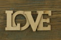 Love word, small hearts on dark wood background. Top view of Valentine`s Day