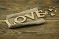 Love word, small hearts on dark wood background. Top view of Valentine`s Day