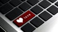 Love word and white heart icon on laptop keyboard red button. Royalty Free Stock Photo