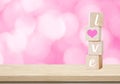 Love word on wooden cubes over blur bokeh background, valentine concept