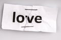 Love word written on torn and stapled paper Royalty Free Stock Photo