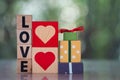 Love word written on wood block with heart shape and gift box Royalty Free Stock Photo