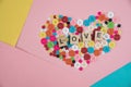 Love word written on wooden block placed on colourful button in Royalty Free Stock Photo