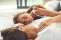 Love is always worth staying in. a happy young couple relaxing in bed together at home. Royalty Free Stock Photo